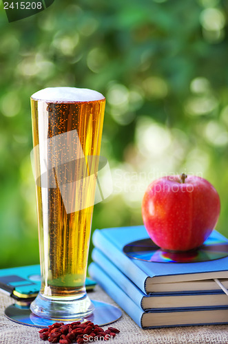 Image of Cold beer and apple on books