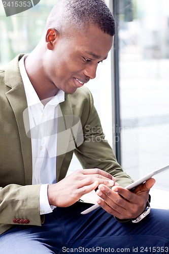 Image of smiling successful businessman with tablet pc outdoor