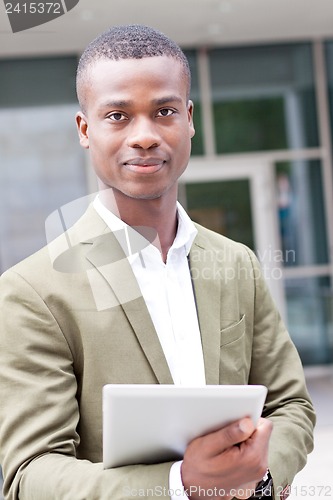 Image of smiling successful businessman with tablet pc outdoor