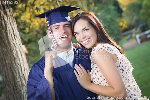 Image of Male Graduate in Cap and Gown and Girl Celebrate