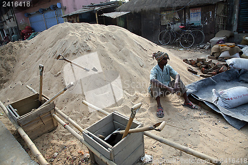 Image of Man working on construction of new road in Kumrokhali, West Bengal, India