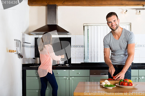 Image of Couple Cooking In Domestic Kitchen