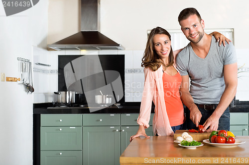 Image of Happy Couple Cutting Vegetables At Kitchen Counter
