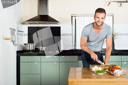 Image of Man Cutting Vegetables At Kitchen Counter