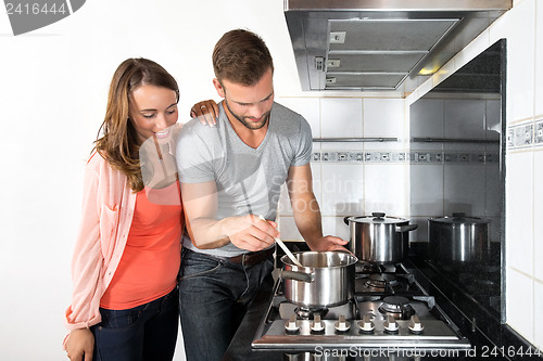 Image of Couple Cooking A Meal On Stove