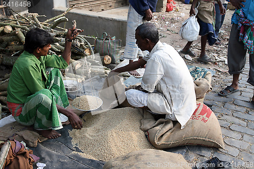 Image of Man selling rice at a street stall outside the market in Kumrokhali, West Bengal, India