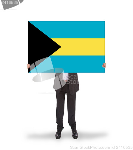 Image of Businessman holding a big card, flag of the Bahamas