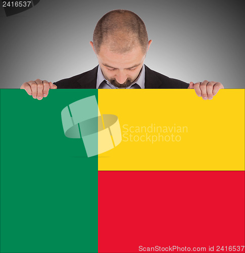 Image of Businessman holding a big card, flag of Benin