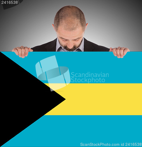Image of Businessman holding a big card, flag of the Bahamas