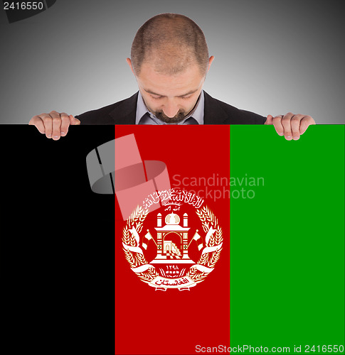 Image of Businessman holding a big card, flag of Afghanistan