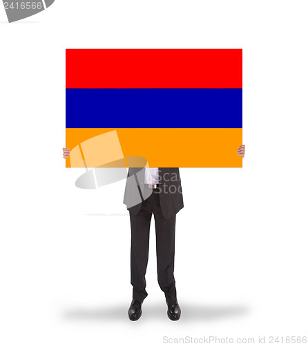 Image of Businessman holding a big card, flag of Armenia