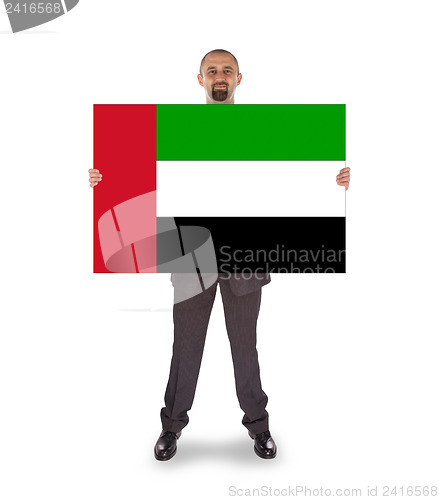 Image of Businessman holding a big card, flag of the United Arab Emirates