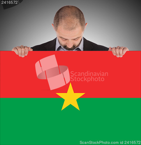 Image of Businessman holding a big card, flag of Burkina Faso
