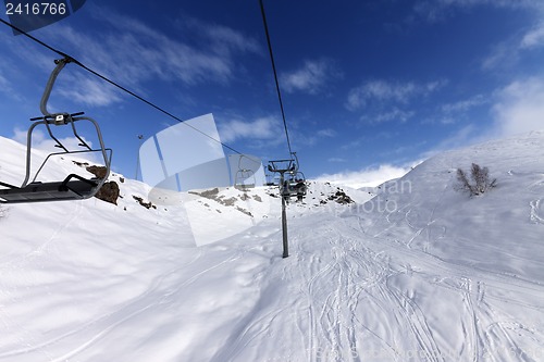 Image of Chair-lift with skiers at winter mountains