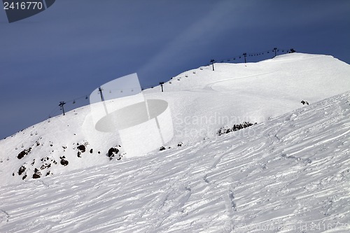 Image of Off-piste slope and ropeway against blue sky