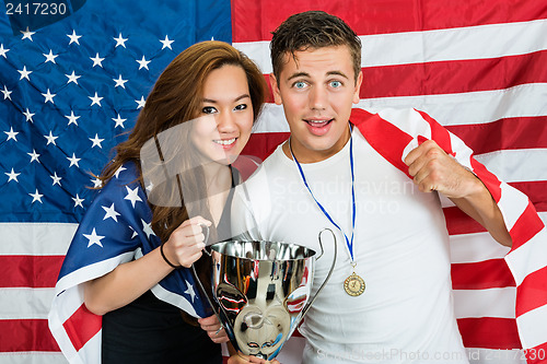 Image of Athletes With Trophy And Medal Standing Against North American F