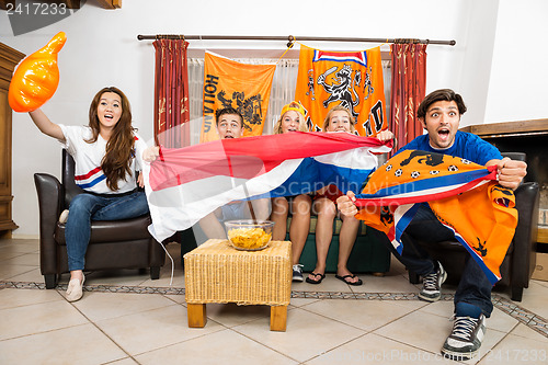 Image of Soccer Fans Cheering While Watching Match At Home