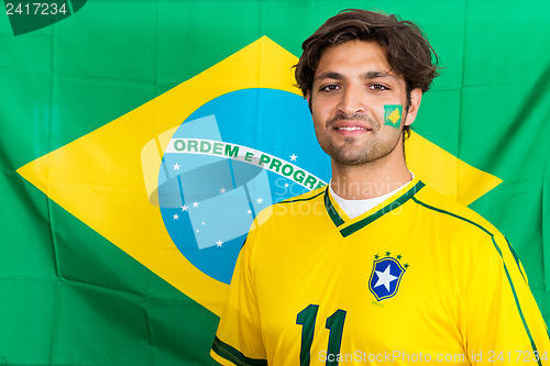 Image of Confident Brazilian Supporter Standing in front of Brazilian Fla