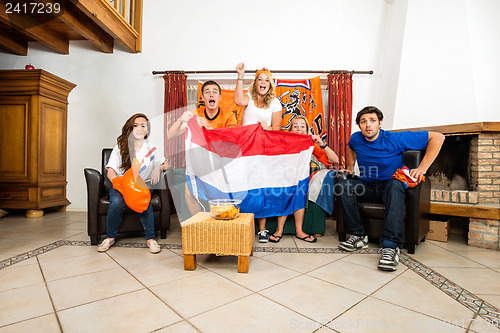Image of Soccer Fans Cheering While Watching Match At Home