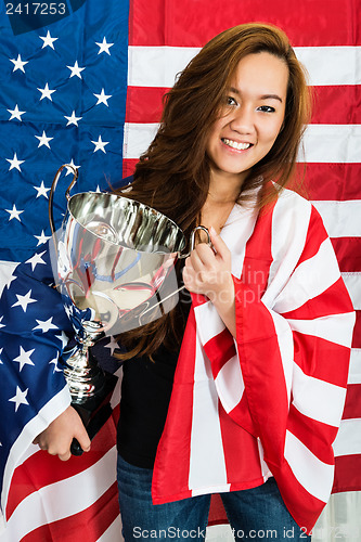 Image of Sportswoman Holding Trophy Against North American Flag