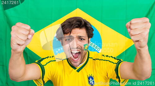 Image of Successful Sportsman Shouting Against Brazilian Flag