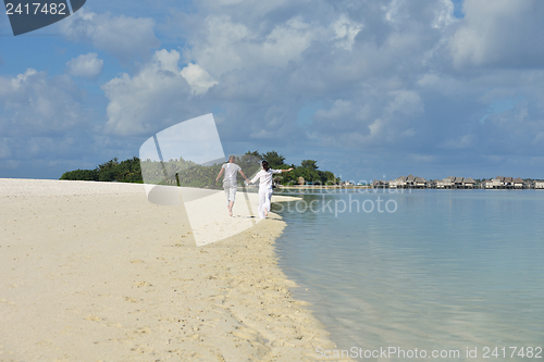 Image of happy young couple have fun on beach