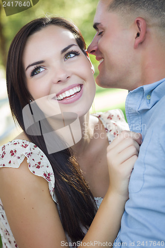 Image of Mixed Race Romantic Couple Whispering in the Park