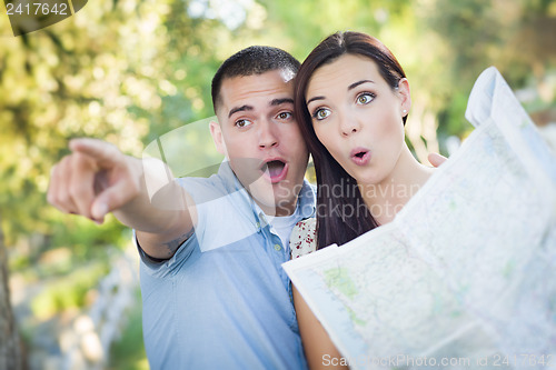 Image of Mixed Race Couple Looking Over Map Outside Together