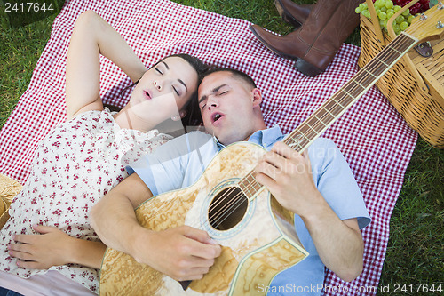 Image of Mixed Race Couple at the Park Playing Guitar and Singing