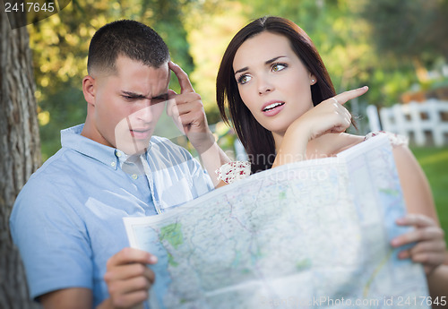 Image of Lost and Confused Mixed Race Couple Looking Over Map Outside