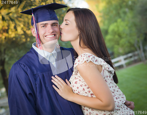 Image of Male Graduate in Cap and Gown and Girl Celebrate