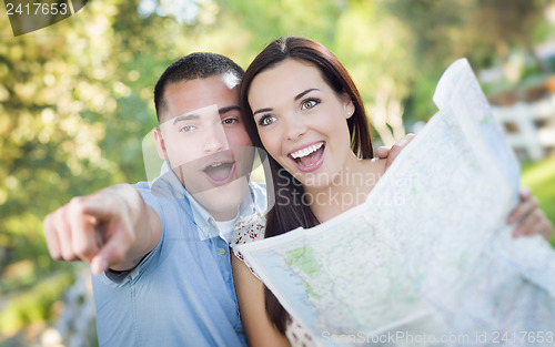 Image of Mixed Race Couple Looking Over Map Outside Together