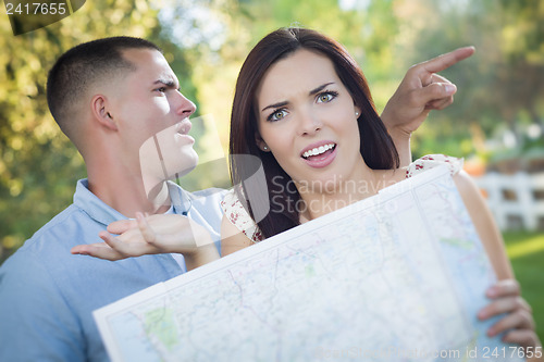 Image of Lost and Confused Mixed Race Couple Looking Over Map Outside