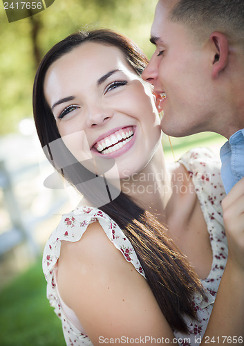 Image of Mixed Race Romantic Couple Whispering in the Park