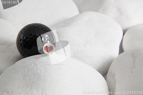 Image of Black golf ball and red heart