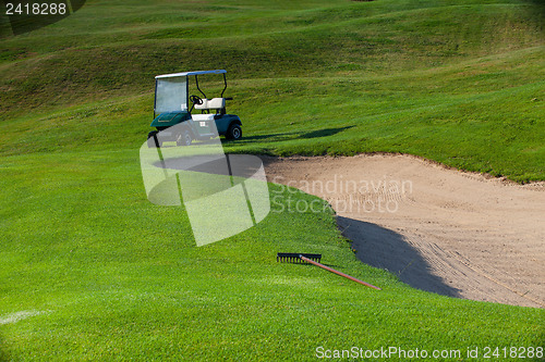 Image of Green golf cart on the empty golf course