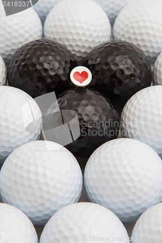 Image of White and black golf balls and wooden tee