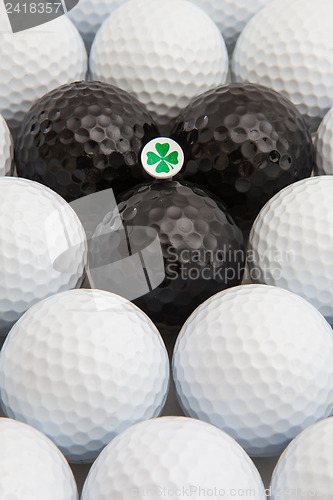 Image of White and black golf balls and wooden tee