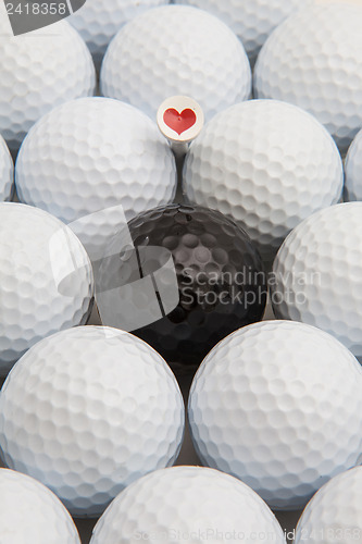 Image of White and black golf balls and wooden tees