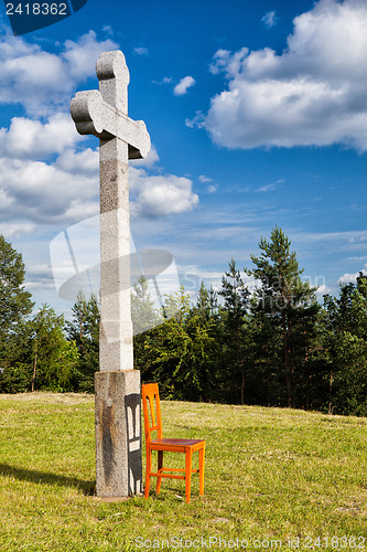 Image of The stone cross and empty wooden chair
