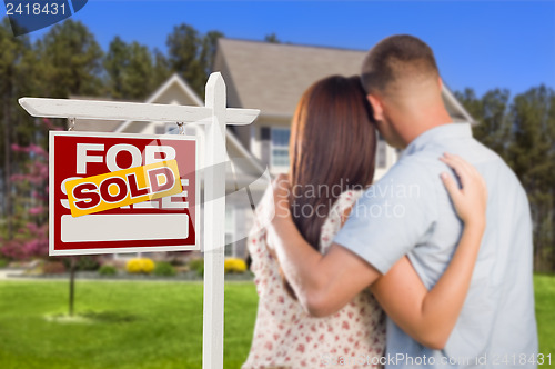 Image of Sold For Sale Sign with Military Couple Looking at House