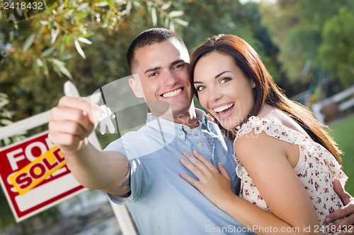 Image of Military Couple with House Keys and Sold Real Estate Sign