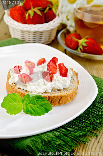 Image of Bread with curd cream and strawberries on a board