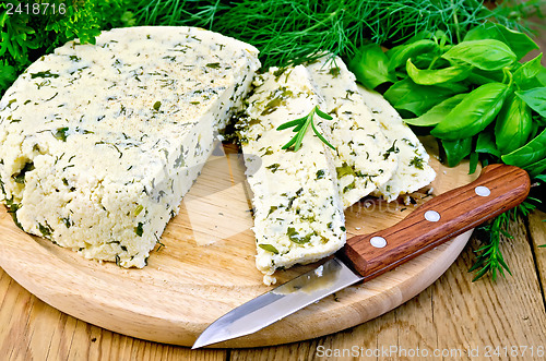 Image of Cheese round homemade with condiments and a knife