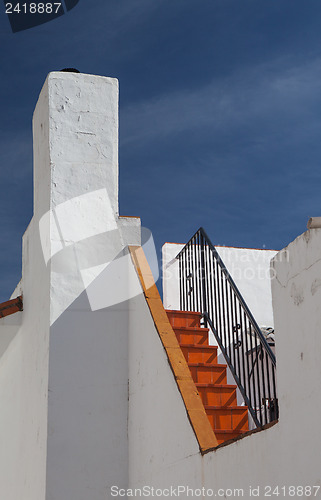 Image of Detail of white house under blue sky 