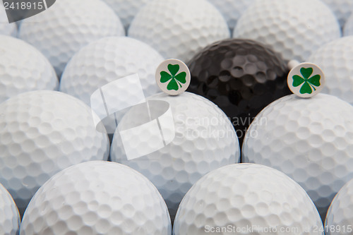 Image of White and black golf balls and wooden tees