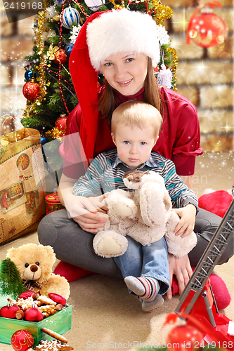 Image of Young woman in a Santa hat and little boy.