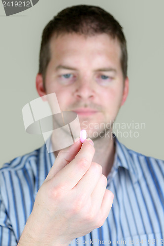 Image of Man holding a Pill
