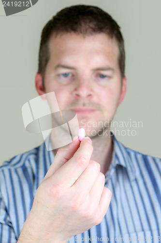 Image of Man holding a Pill
