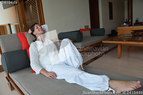 Image of happy young woman relax at home on sofa